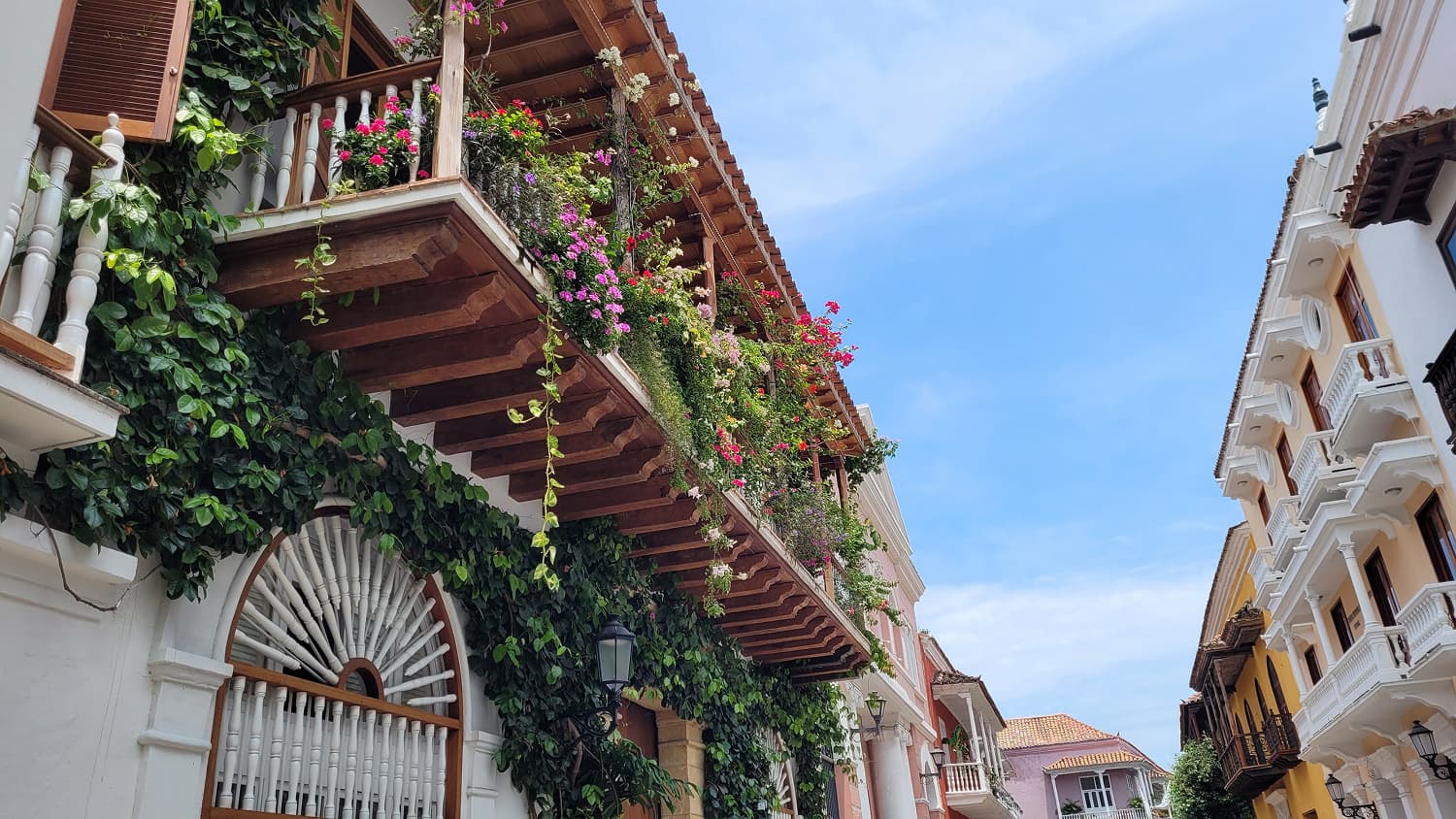 A sunny street with flower-filled balconies